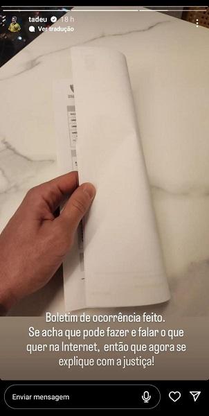 Publicação no Instagram de Tadeu. Ele segura um papel dobrado, afirmando ser o comprovante do boletim de ocorrência, e pede que a justiça seja feita.