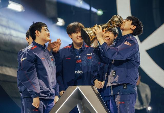 Ruler, da JD Gaming, beija o troféu do MSI 2023 enquanto seus companheiros de equipe celebram