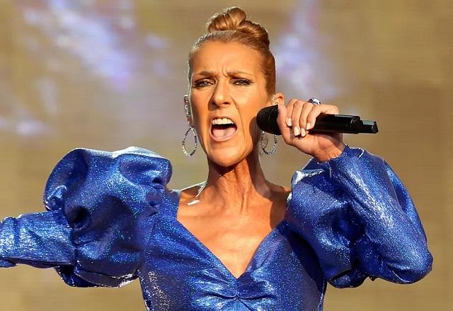 Celine Dion cantando, com o microfone na mão, durante um sho