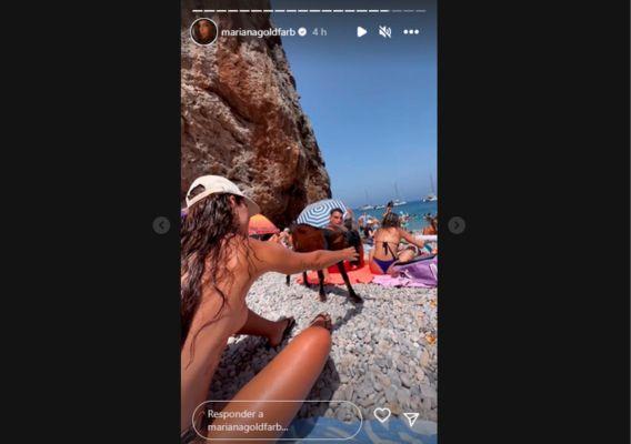 Mariana Goldfarb na praia, de topless