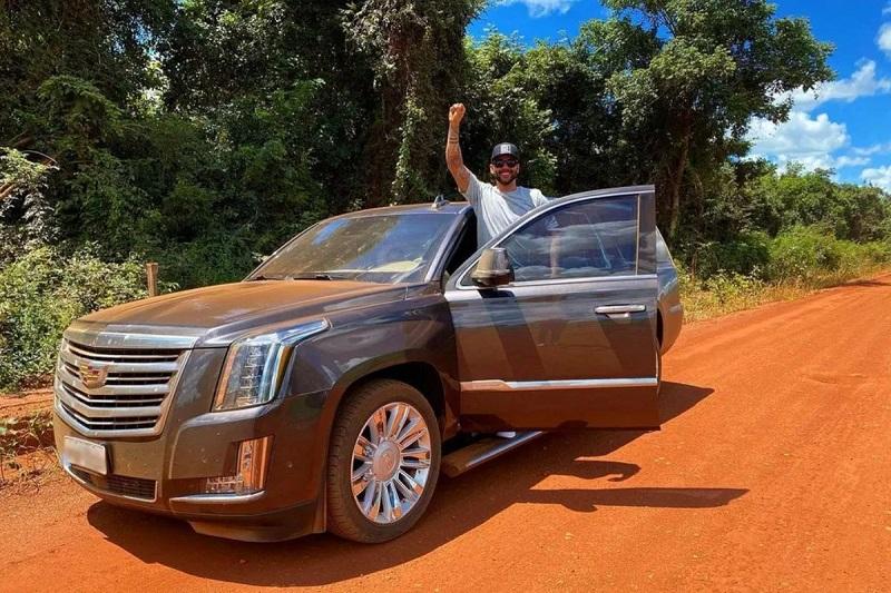 Gusttavo Lima posa ao lado de uma Cadillac Escalade