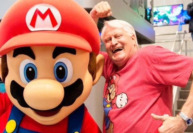 Foto de Charles Martinet ao lado de uma estátua do Mario