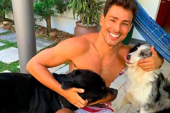 Cauã Reymond posa sorrindo com seus animais de estimação