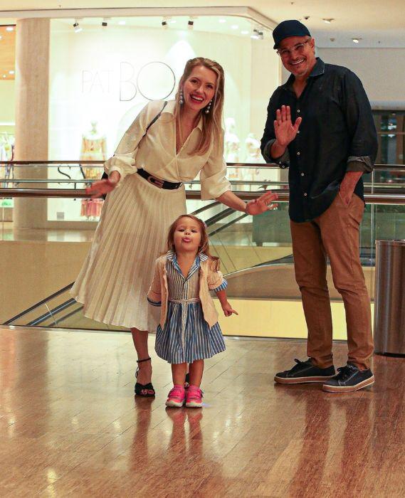 Karin Roepke, Edson Celulari e a filha Chiara sorrindo para fotógrafos em um shopping no Rio de Janeiro, ambos estão rindo