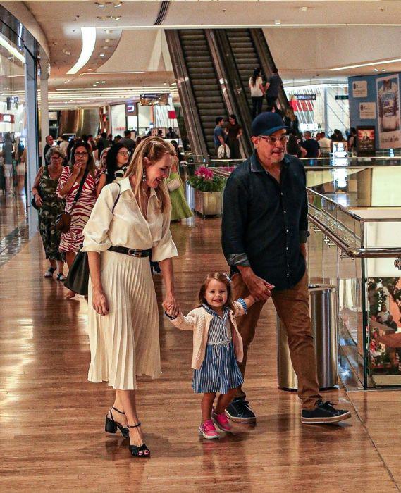 Karin Roepke, Edson Celulari e a filha Chiara sorrindo para fotógrafos em um shopping no Rio de Janeiro