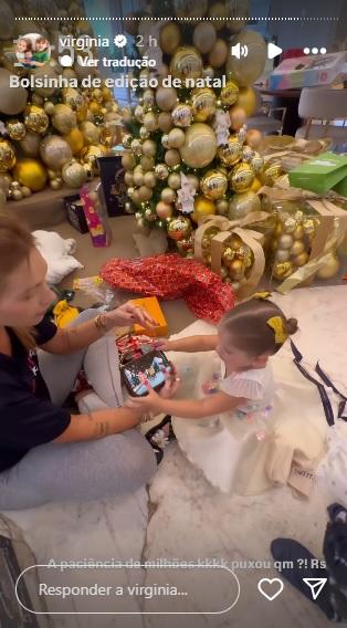 Virginia abrindo presentes com filhos.