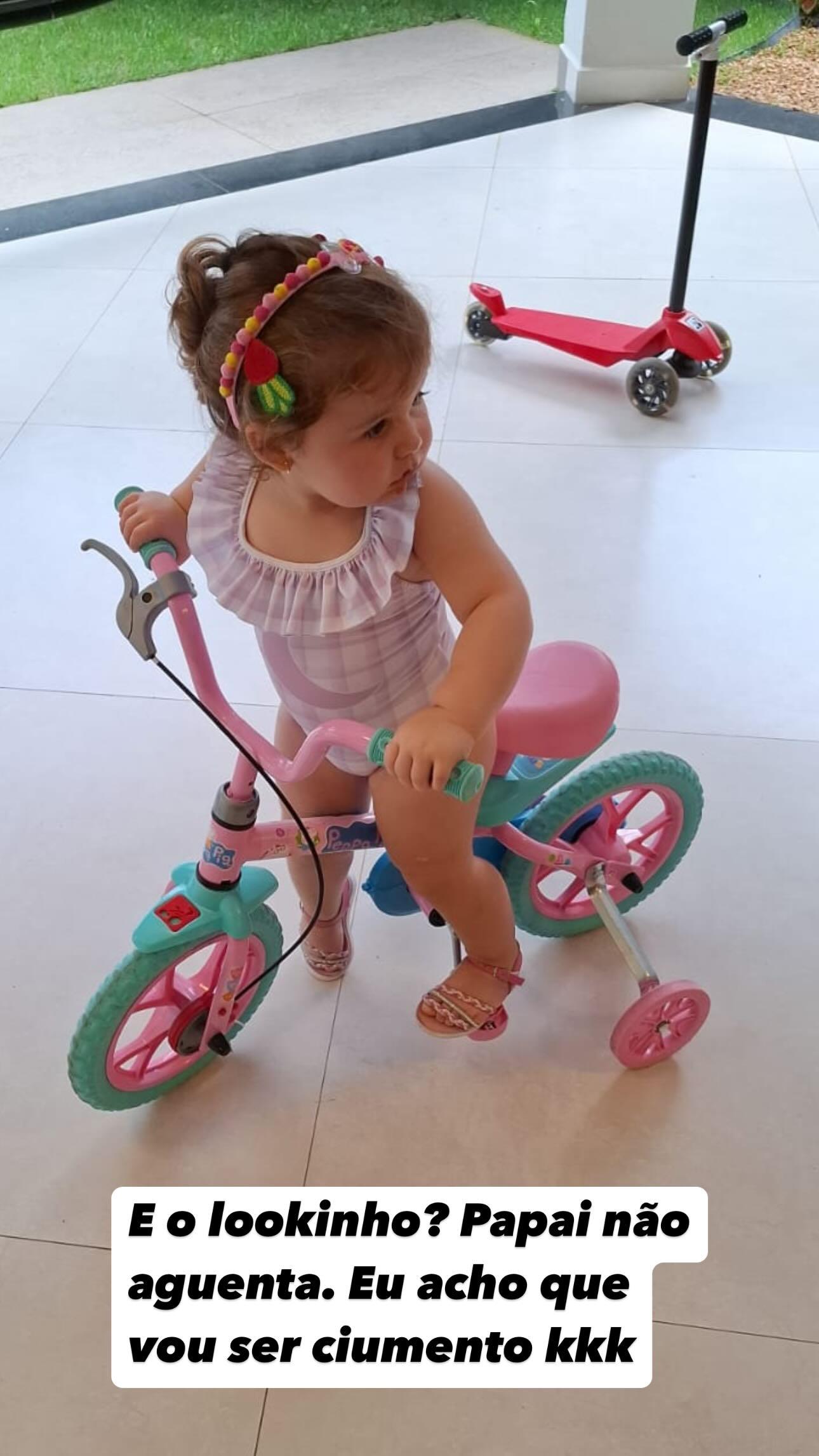 uma bebê andando de bicicleta