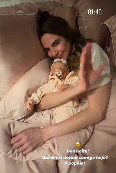 Luciana Gimenez deitada com um bebê reborn