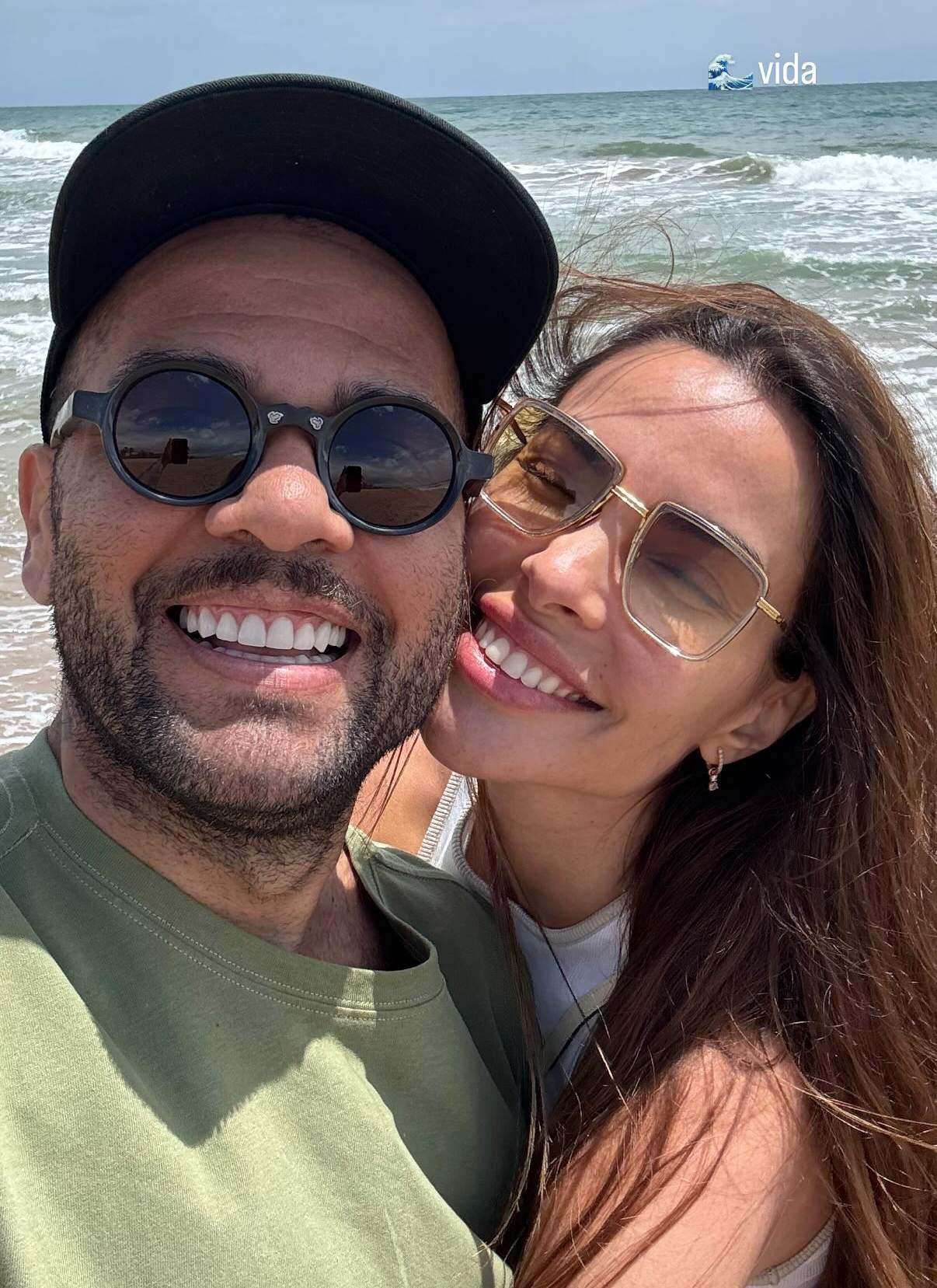 Daniel Alves sorrindo e esposa