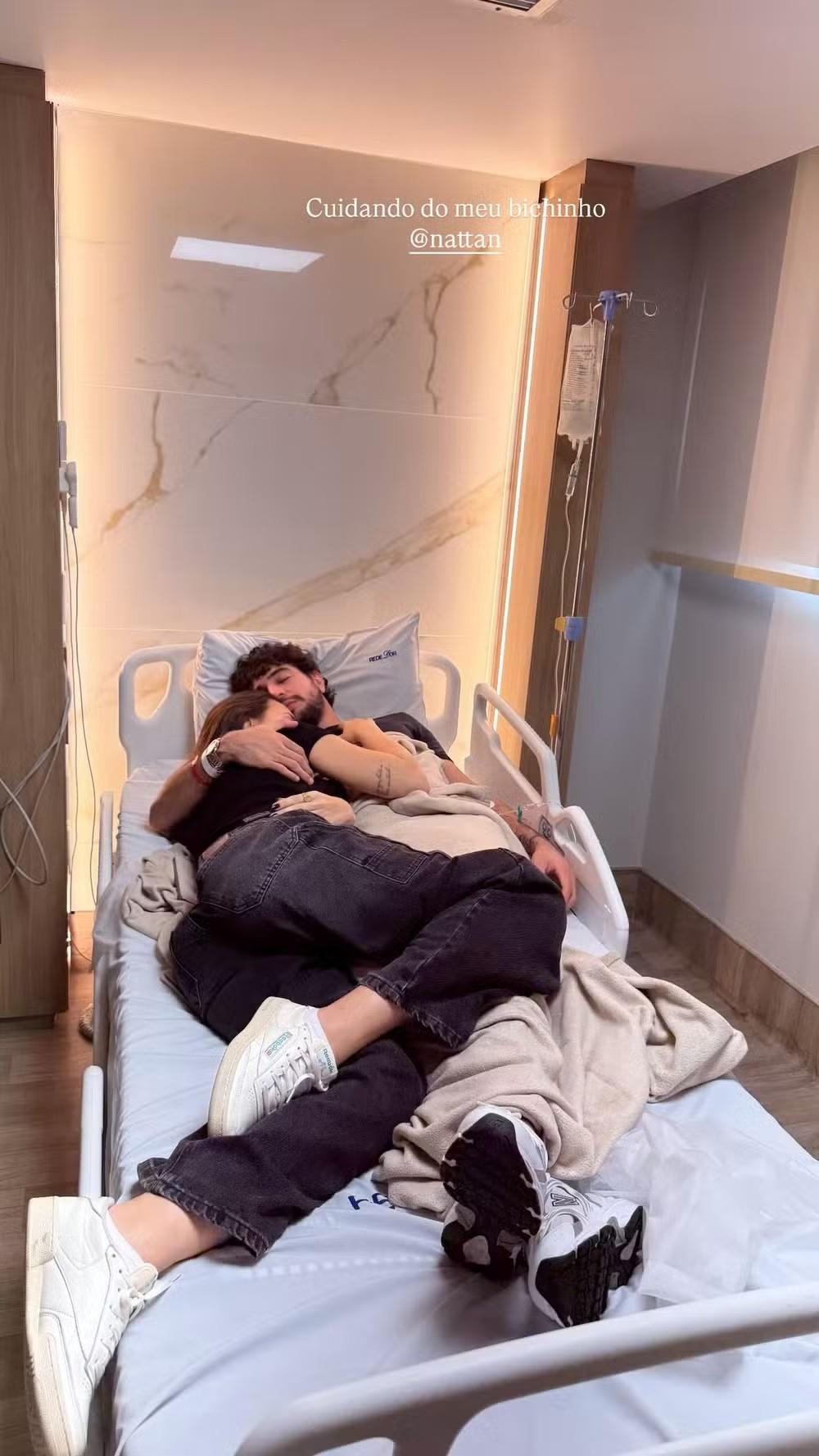 Nattanzinho e Rafa Kalimann deitados na cama do hospital