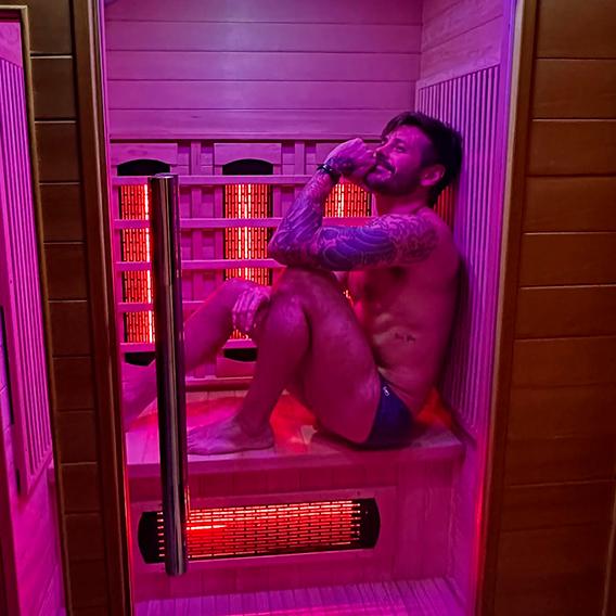 Dado Dolabella posando de sunga sentado em uma sauna