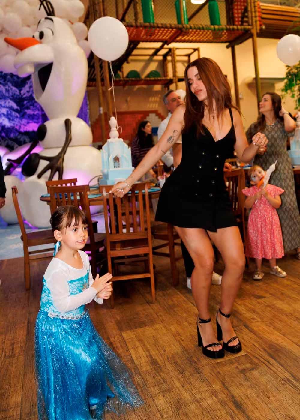 Ava e Anitta dançando juntas durante festa.
